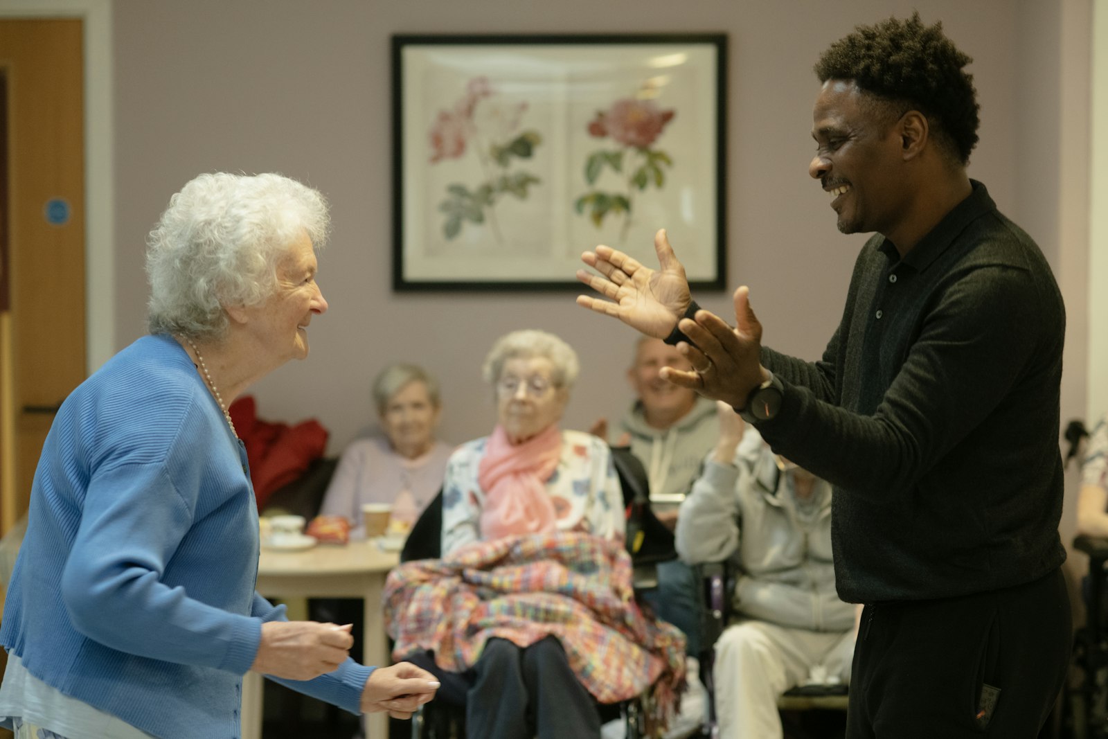 Care worker sharing a lively moment with an elderly resident