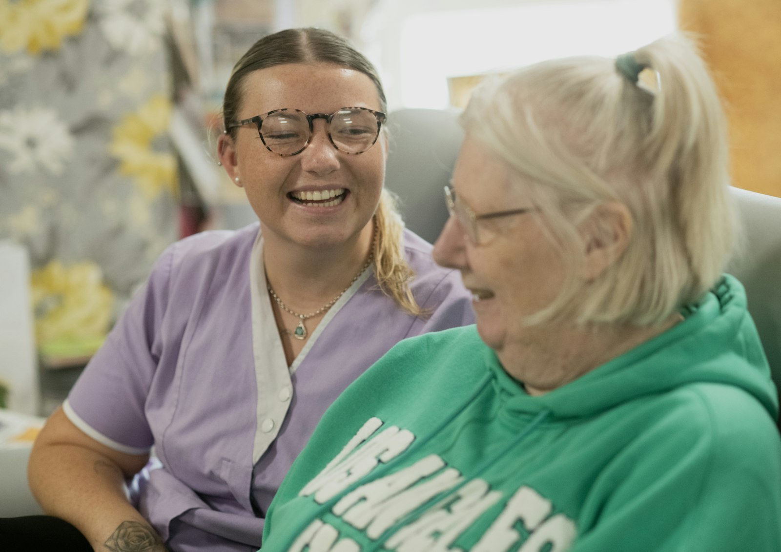 Caregiver sharing a laugh with an elderly resident in a skilled nursing facility